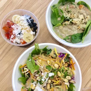 two bowls of salad and a bowl of dressing