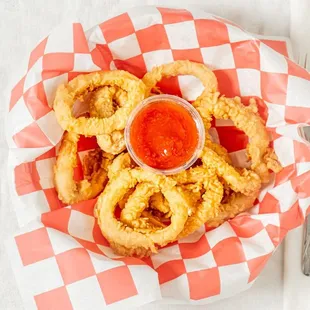 a basket of fried squid rings with ketchup