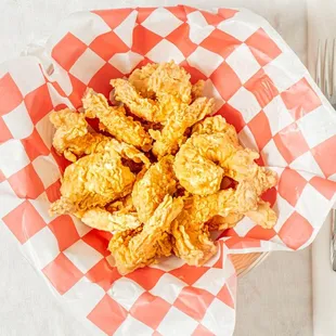 a basket of fried food with a fork and knife