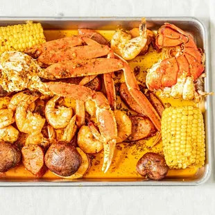 cooked crab legs, corn and potatoes