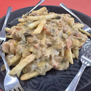 Loaded fries  shrimp and crawfish tail in a cheese sauce with mushrooms, and Cajun Trinty.