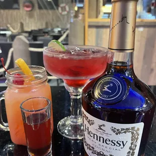 a bottle of hennessy and a glass of gin