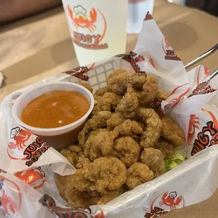 a basket of fried shrimp and dipping sauce
