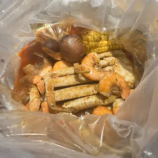 Crab legs, shrimp, potatoes and corn.