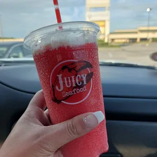 a hand holding a cup of juice