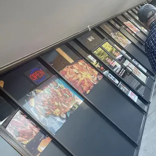 a man standing in front of a wall of menus