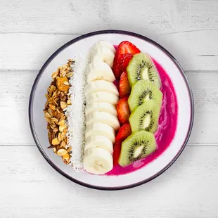 Pitaya Mama:
Dragon fruit, pineapple, banana, coconut milk. Toppings: kiwi, strawberries, banana, coconut flakes, and house made granola