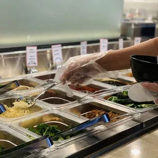 a person preparing food in a buffet