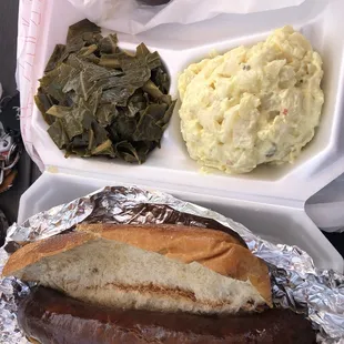 a hot dog, mashed potatoes, and collar greens