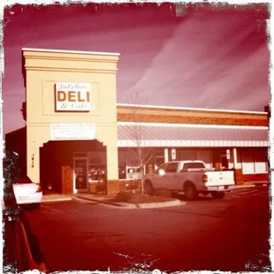 a truck parked in front of a deli