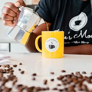 a man pouring coffee into a mug