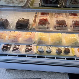 a display case of cakes and pastries