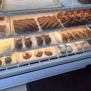 a display case of pastries and desserts