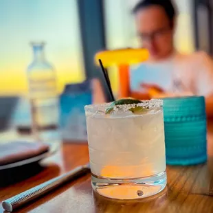 a woman sitting at a table with a drink
