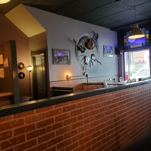 a brick bar with a clock on the wall