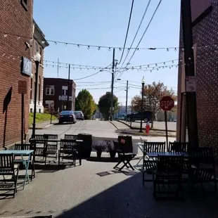 a narrow alley with tables and chairs