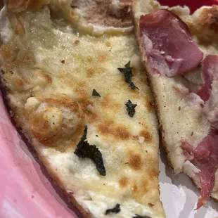 Crust had be taken off to eat  pizzas featured are the white pizza on the left and artichoke pizza is on the right