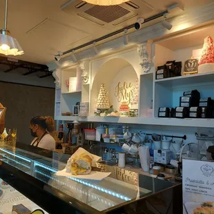 a woman behind a counter in a bakery