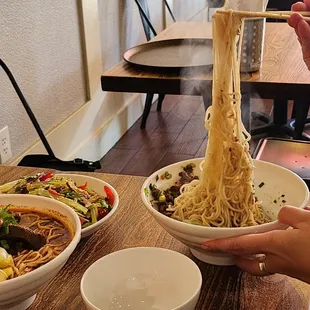 two bowls of noodles with chopsticks