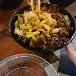 a bowl of noodles with chopsticks