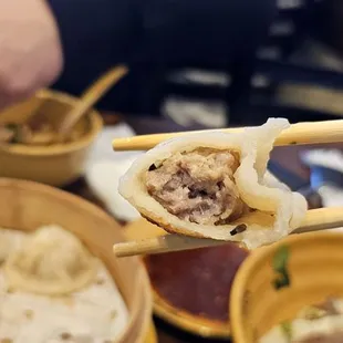a person holding chopsticks over a bowl of food
