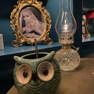 a green owl shaped vase with a candle