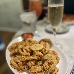 a plate of fried calamails and a glass of champagne
