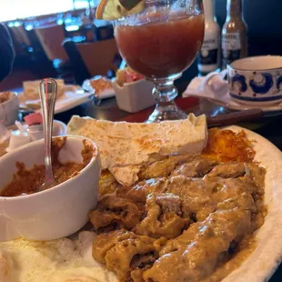 Vaccaro chicken fried steak, fried eggs, sides of hash browns, refried beans, flour tortillas. Bloody Mary