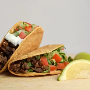 two tacos on a cutting board