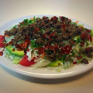 $12.30 for a house salad topped with 3 tacos worth of beef, onion and cilantro.