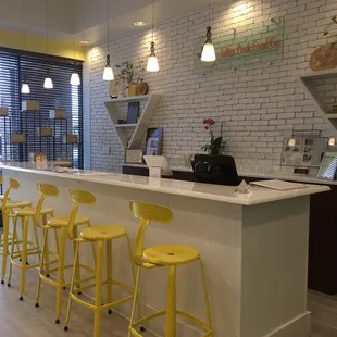 a counter with yellow stools