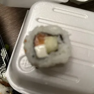 a sushi in a styrofoam container