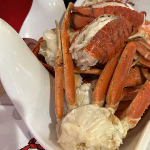 Seafood boil with sauce and seasoning on the side.