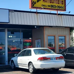 a white car parked in front of a restaurant