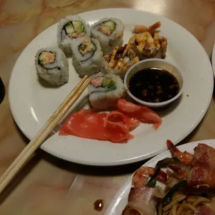 a plate of sushi with chopsticks
