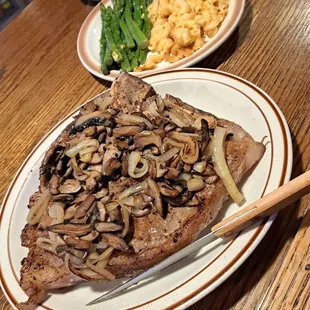 Porterhouse steak smothered in mushrooms and onions, asparagus and homemade Mac and cheese.