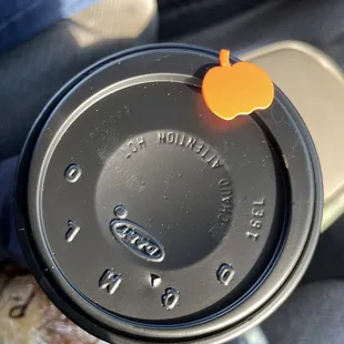 a coffee cup with an apple on top