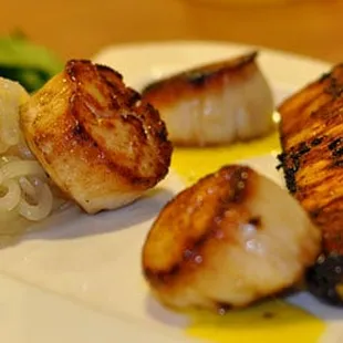 scallops and onions on a white plate