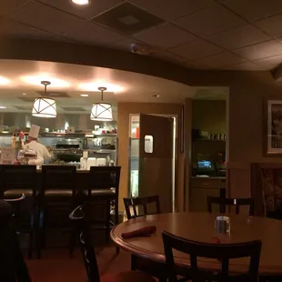 An open kitchen, and the chef with a tall hat! The only downside is you have to watch your food sitting there and hope your server notices.