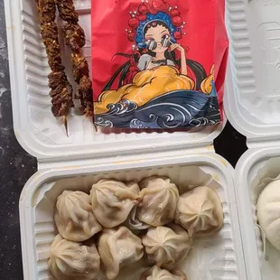 soup dumpling with dipping sauce and chili oil included. Beef skewers on top. Came out super hot
