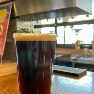 a glass of beer on a bar counter