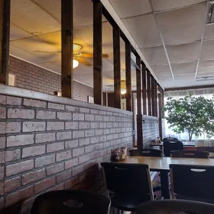 a brick wall and tables and chairs