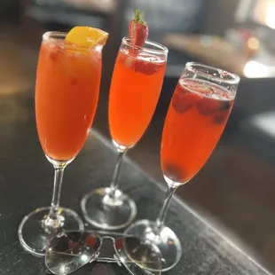 Refreshing fresh fruit mimosas- (L 2 R) Strawberry/Orange mimosa, Strawberry/Pineapple mimosa, Mixed Berry mimosa