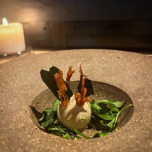 a plate of food with a candle in the background
