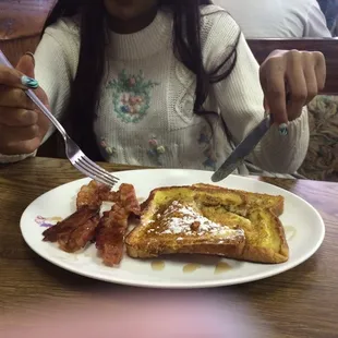 My daughter&apos;s two-stack French toast with bacon and powdered sugar $5.00,