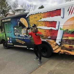 a woman standing in front of a food truck
