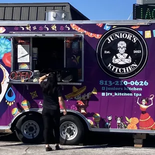 a woman ordering food from a food truck