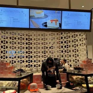 a woman standing in front of a display case