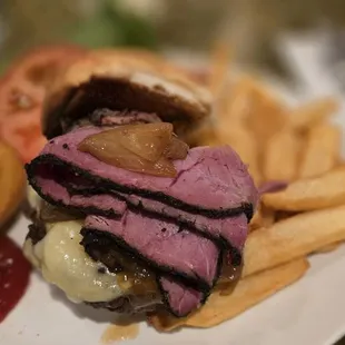 Pastrami-Swiss Cheeseburger with onion rings and steak fries.