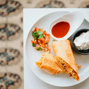 a burrito with a side of salsa